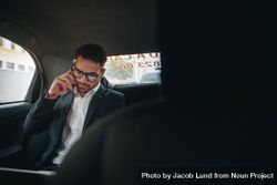 Businessman managing office work on the move sitting in a cab 5lGGN0