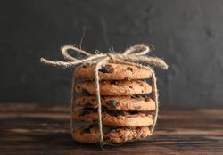Stack of tasty chocolate chip cookies on wooden table. Space for text
