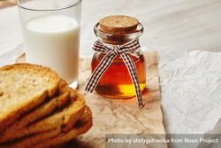 Pot of honey with stack of toast and glass of milk 5rGeP4