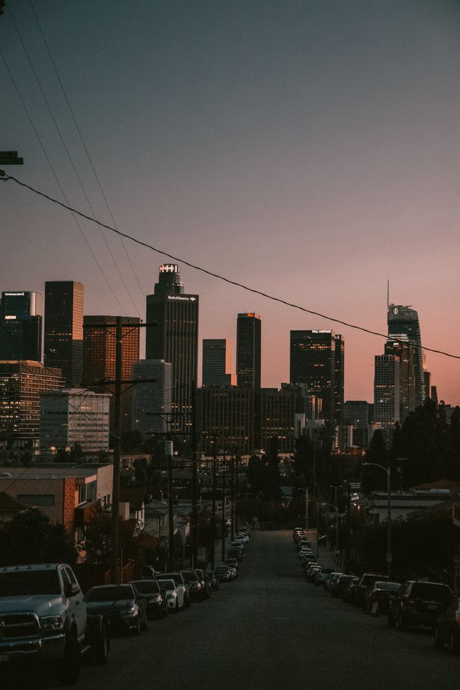 Road between city buildings at sunset
