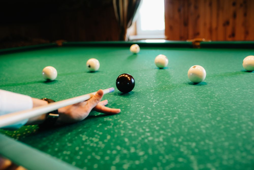 Person playing billiard indoor