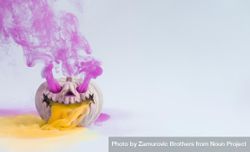 Pumpkin skull with purple and orange smoke on light wall with 4dolA5