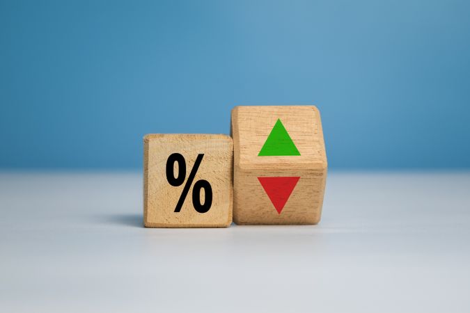 percentage symbol with up and down arrow on wooden isolated on white and blue background. concept of interest rate financial and mortgage rate growth
