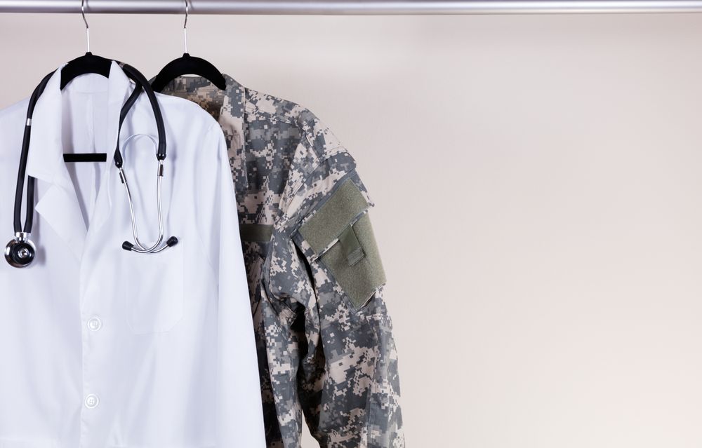 Medical consultation coat and military uniform on hanger