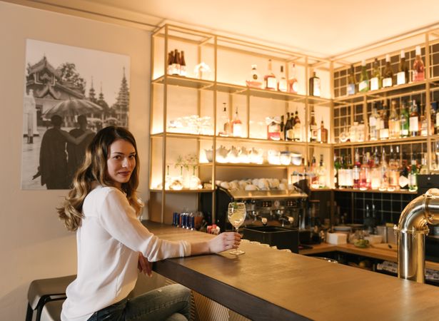Young woman enjoying cocktail in bar