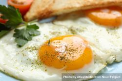 Close up of blue plate with two sunny side up eggs and toast 41g7j0