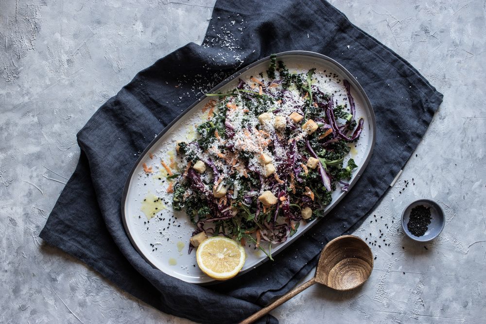 Poppy seeds and lemon near vegetable salad with croutons and parmesan