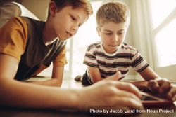 Two boys playing a game on tablet pc with great interest 5kraW0