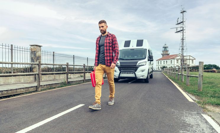 Man walking in front of parked van with gas can