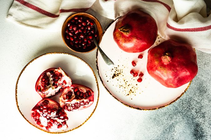 Fresh cut pomegranate on light plate with dishtowel