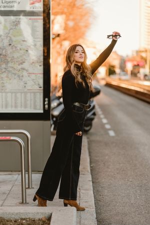 Cheerful woman hailing taxi
