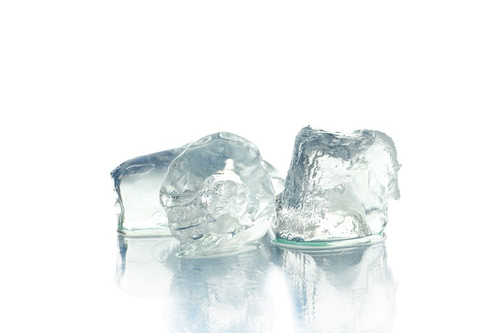 Three ice cubes in plain room