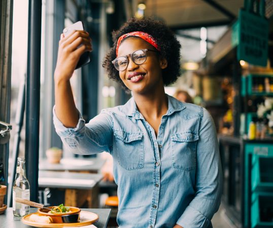 Woman taking selfie at a cafe