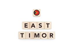 Wooden blocks bearing the name and flag of East Timor. Timorese and Austral Culture, national identity, travel, and geography in a copy space design.