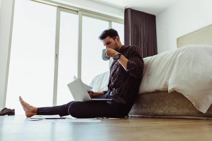 Man working from home enjoying coffee on the floor