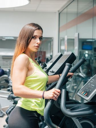 Young woman exercising on modern machine