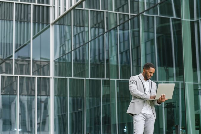 Black man holding laptop on street