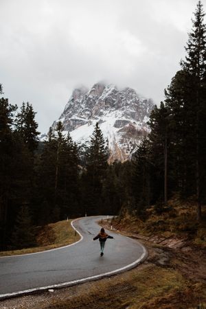 Lonely traveler among pine forest near big cliffs