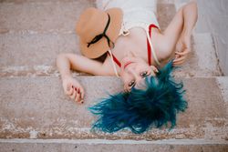 Sensual woman in sundress lying on pier stairs
