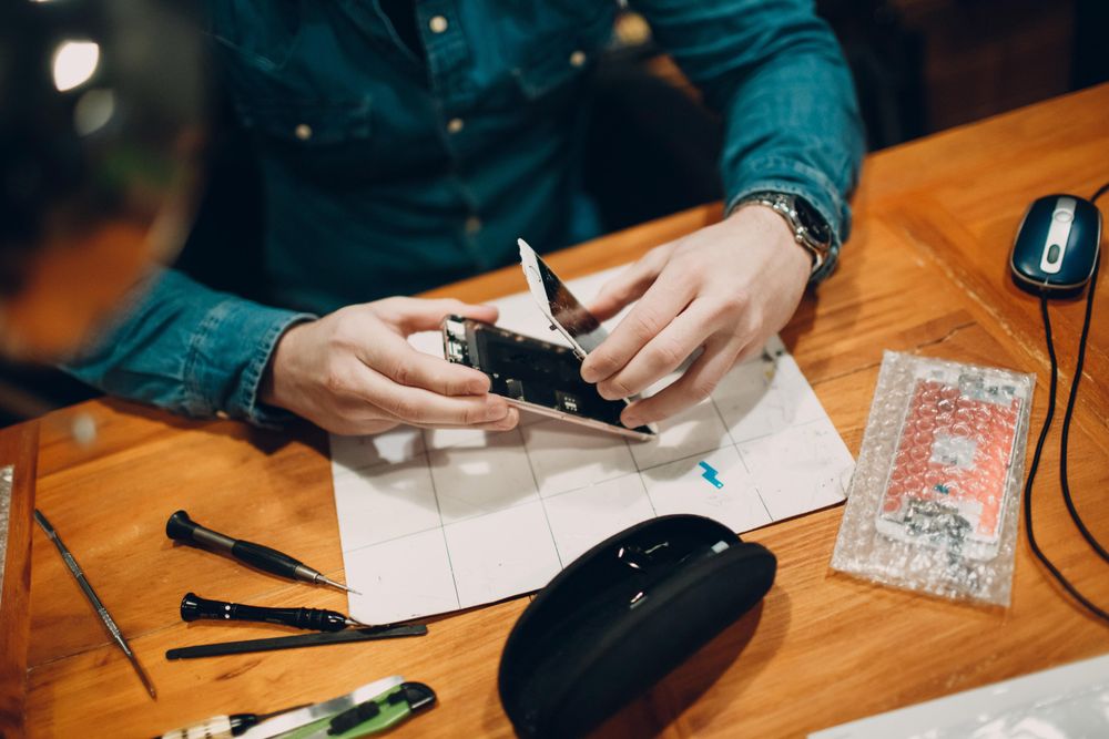 Mobile technician removing the screen from a smartphone
