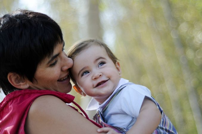 Mother hugging baby girl in forest