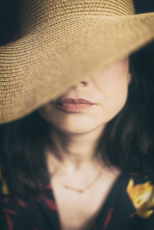 Portrait of mature woman wearing sun hat covering her eyes