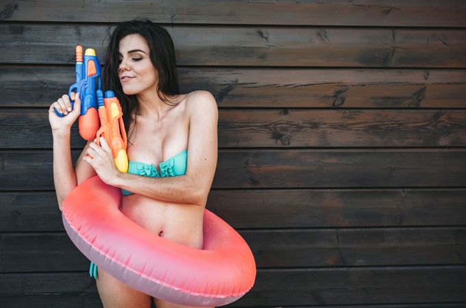 Young woman with two water guns posing