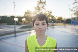 Portrait of a teenage male wearing a yellow basketball sleeveless shirt on court 5n8Dmb
