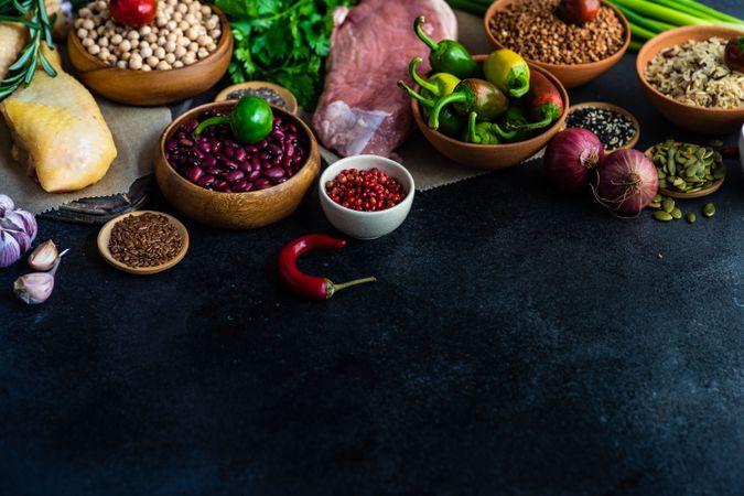 Dark kitchen counter with dried ingredients for turkey leg and pork cutlet meal