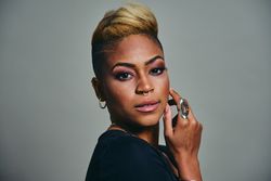 Portrait of Black woman with short blonde hair in grey space