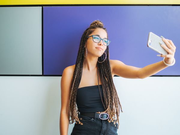 Woman with dreadlocks in glasses taking selfie