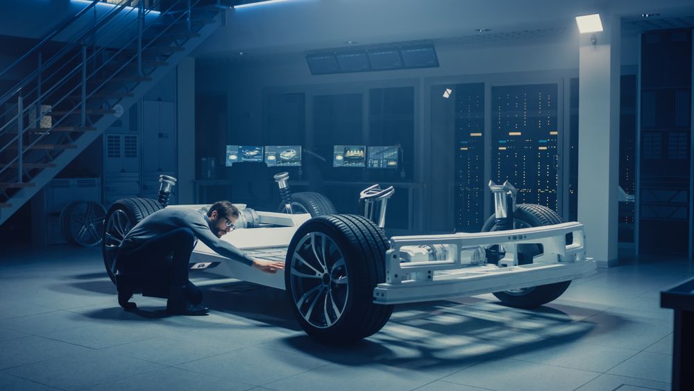 Automobile Engineer Working on Electric Car Platform Chassis Prototype, Using Tablet Computer with 3D CAD Software Modelling.