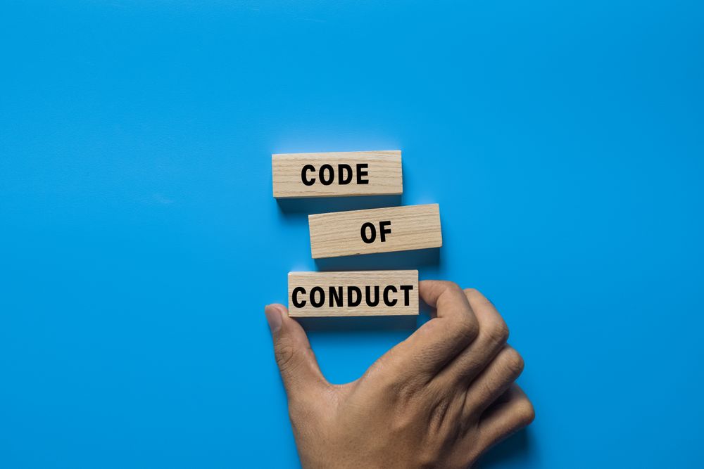 code of conduct words on wooden blocks isolated on blue background
