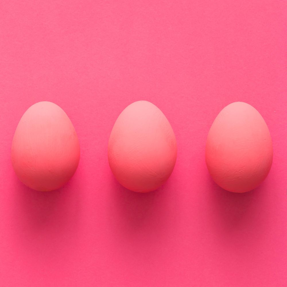 Row of three pink Easter eggs on pink background
