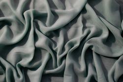 Nude green fabric wavy crumpled background texture with copy space.