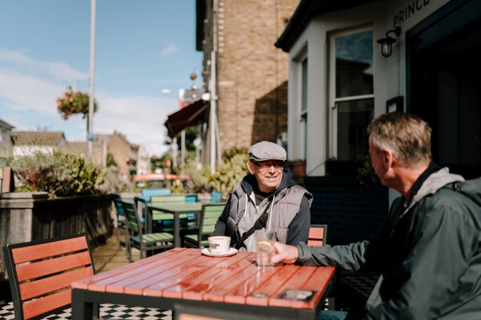 Two older men at an outdoor table