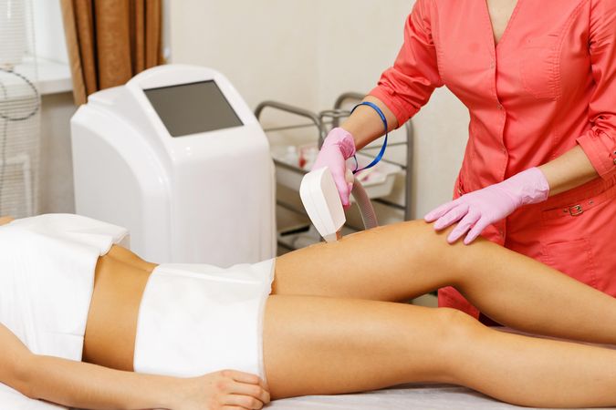 Woman having hair removed on thigh with laser treatment