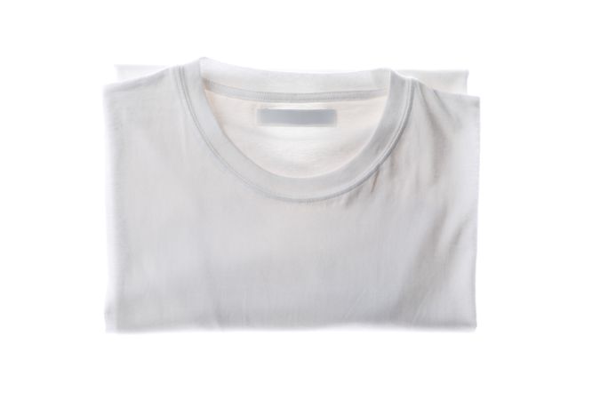 Folded plain t-shirt isolated on plain background, space for text