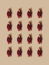 Pattern of pomegranate fruit slices and pastel sand background