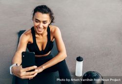 Woman in athletic gear taking selfie on yoga mat 5qANK5