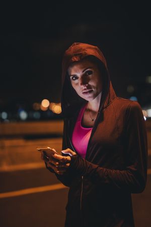 Female runner taking break after workout at night