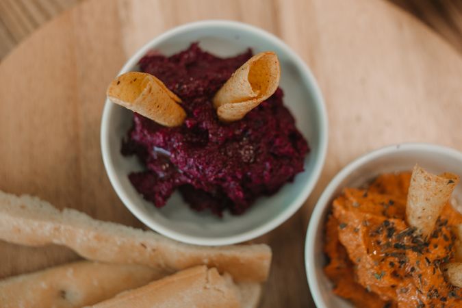 Different tasty sauces on round wooden stand