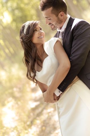 Newlyweds taking photos in a sunny park, vertical