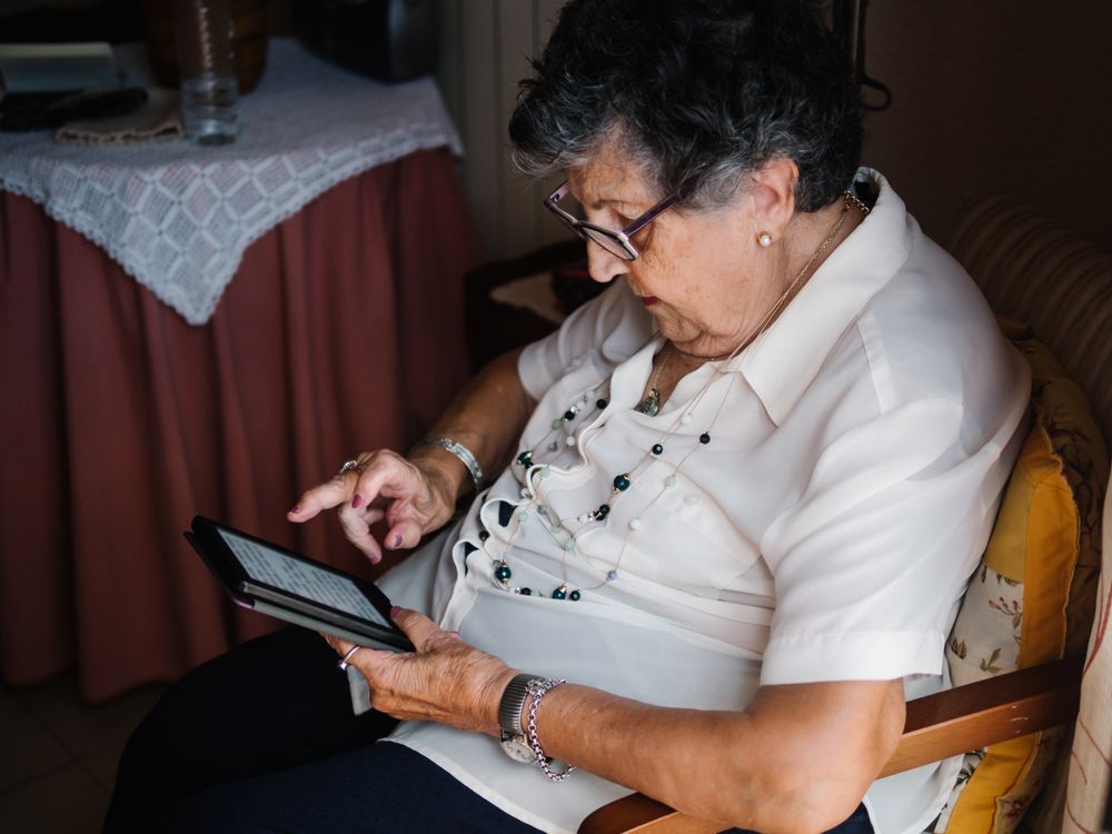Mature female reading e-book at home