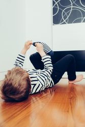Cute blonde boy putting on his socks