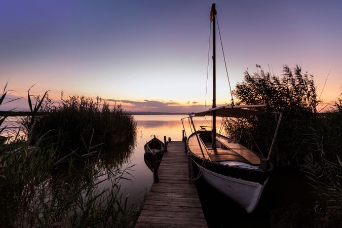 Moored boat by wooden pier