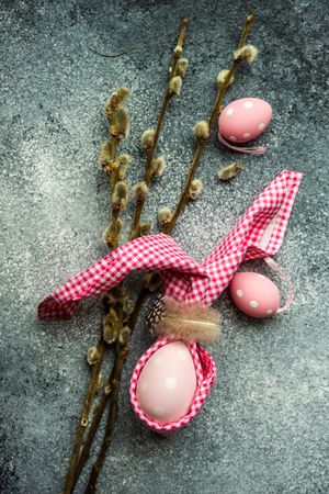 Pink egg decorations on grey counter with pussy willow