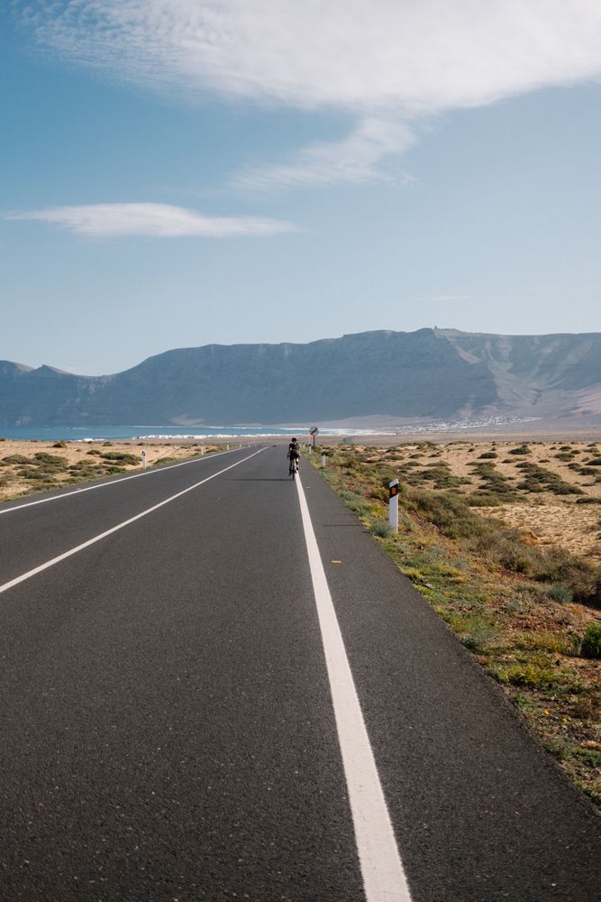 Person on bike in distance cycling towards ocean