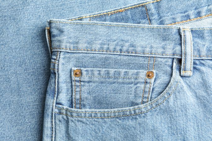 Closeup view of jeans pocket as background, space for text