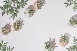 Brown eggs wrapped in leaves scattered on light  background